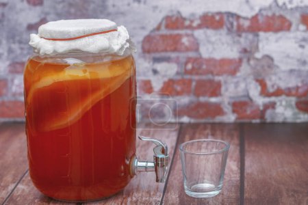 glass jar with homemade kombucha, scoby, with a tap for serving