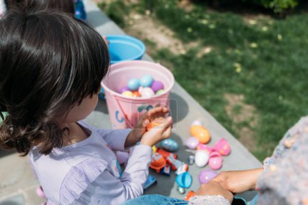 Téléchargez les photos : Jeune fille tenant des bonbons d'une chasse aux œufs de Pâques - en image libre de droit