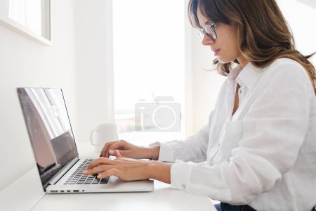 Téléchargez les photos : Woman Working from Home Office on a Laptop Typing - en image libre de droit