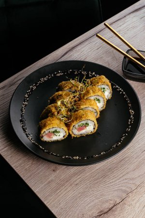 Foto de Tempura sushi rolls on a black plate - Imagen libre de derechos
