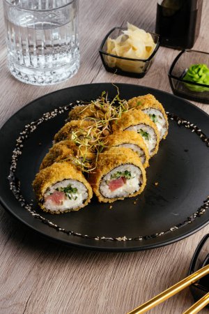 Foto de Tempura sushi rolls on a black plate - Imagen libre de derechos