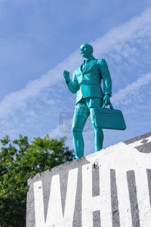 Téléchargez les photos : Black and white mural of Whose World Is This with a turquoise figure of a businessman without pants in Lisbon, Portugal - en image libre de droit