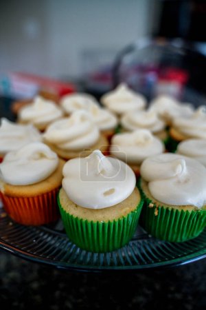 Foto de Vanilla Frosting Cupcakes in Colorful Liners - Imagen libre de derechos