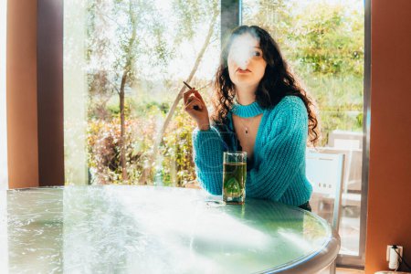 Photo for Lonely woman drinking and smoking at home - Royalty Free Image