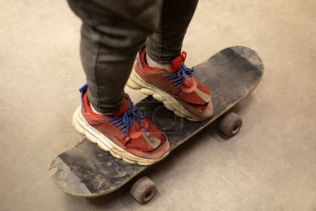 Téléchargez les photos : Un type en skateboard. Trick à bord. Baskets rouges. Sports extrêmes. - en image libre de droit