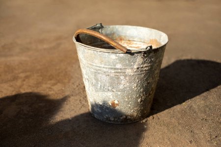 Foto de Old bucket outside. Rusty object. Spoiled metal. Junk on street. - Imagen libre de derechos