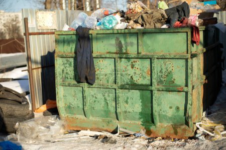 Foto de Dump in city. Large green garbage container. Lots of waste. - Imagen libre de derechos
