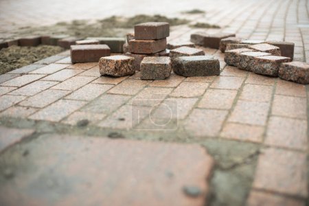 Téléchargez les photos : Repair of tiles on road. Stone is red for square. - en image libre de droit