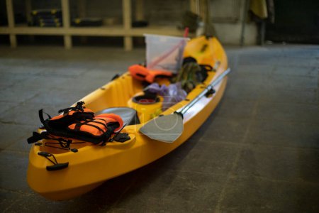 Téléchargez les photos : Yellow boat made of plastic. Canoe in garage. Sports equipment. - en image libre de droit
