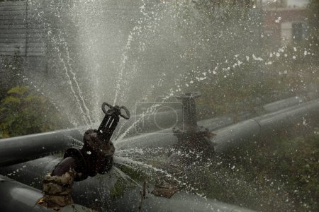 Téléchargez les photos : Valve on tube. Torn pipe valve. Boiling water pours from pipeline. Sewer breakout. - en image libre de droit