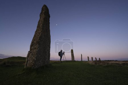 Téléchargez les photos : Photographer standing between Ring of Brodgar standing stones, Orkney, Scotland - en image libre de droit
