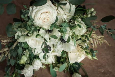 Foto de Close Up of Bouquet of White Roses and Greenery on Table - Imagen libre de derechos