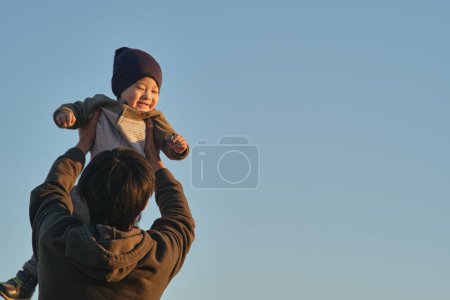 Photo for Father and little son of Asian appearance, father throws up the child - Royalty Free Image