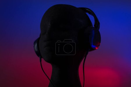 Téléchargez les photos : Over-ear headphones on black head on blue and red background - en image libre de droit