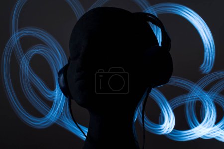 Téléchargez les photos : Blue over-ear headphones on black head on black background - en image libre de droit