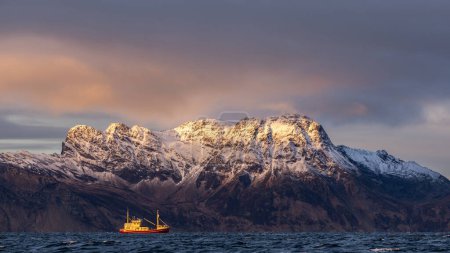 Foto de A small motor boat sails in the norwegian sea in winter - Imagen libre de derechos