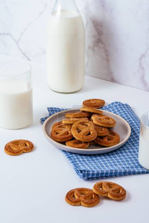 Photo for Milk in a glass and a glass bottle on a white table, cookies in a plate - Royalty Free Image
