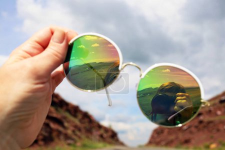 Foto de The camera and the mountains are reflected in sunglasses - Imagen libre de derechos