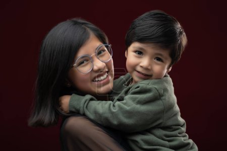 Photo for Mexican siblings hugging on dark background - Royalty Free Image
