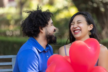 Photo for Mexican young latin couple laughing and talking on valentine's d - Royalty Free Image