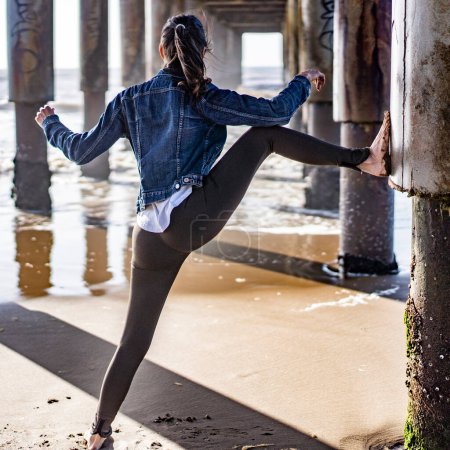 Téléchargez les photos : Rear view of a woman doing stretching exercises outdoors. - en image libre de droit