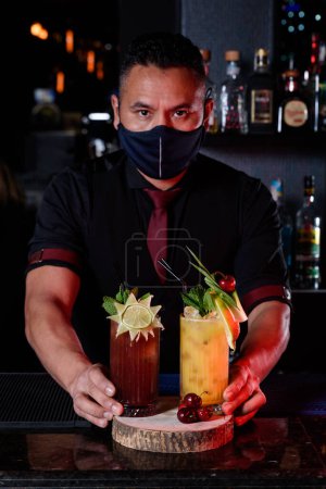 Téléchargez les photos : Professional bartender preparing cocktails at the bar - en image libre de droit