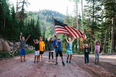 Foto de Primos y niños alegran con alegría con bandera americana - Imagen libre de derechos