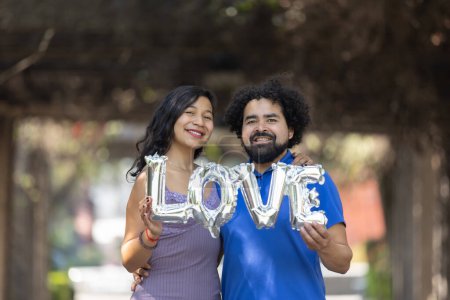 Téléchargez les photos : Mexican young couple holding love balloon - en image libre de droit