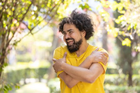 Photo for Young Mexican man with beard and afro hugging himself, self love - Royalty Free Image