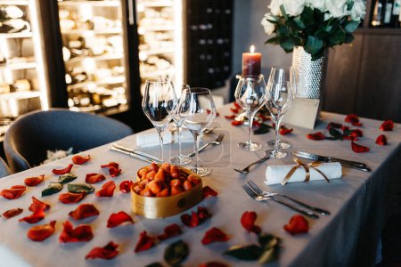 Téléchargez les photos : Table with sparkling wine glasses sprinkled with rose petals - en image libre de droit