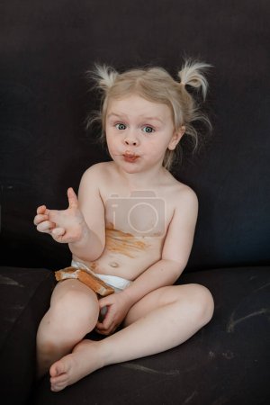 Photo for Young messy girl eating peanut butter snack - Royalty Free Image