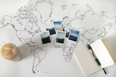 Téléchargez les photos : Polaroid Photos on World Map with Ice coffee and Notebook - en image libre de droit