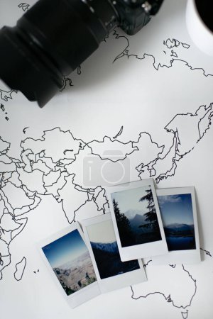 Téléchargez les photos : Polaroid Photos Mise en page des montagnes sur la carte du monde de voyage avec appareil photo - en image libre de droit