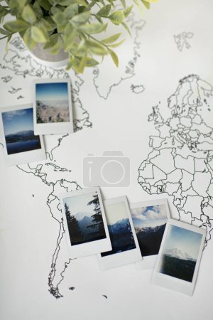 Téléchargez les photos : Mountain Polaroid Photos on Travel World Map with Plant Decor - en image libre de droit