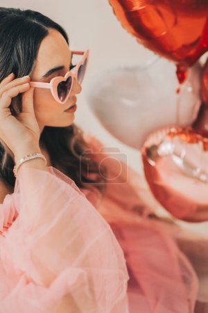 Photo for Woman Holding Heart Sunglasses and Balloons for Valentine's Day - Royalty Free Image