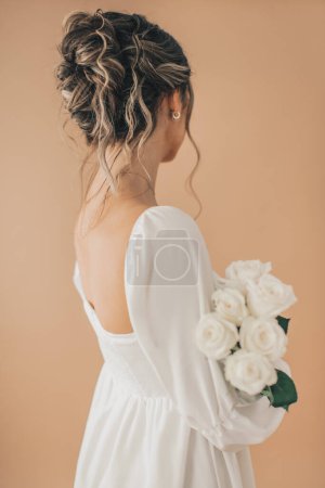 Photo for Detail shot of woman from behind holding white flowers - Royalty Free Image