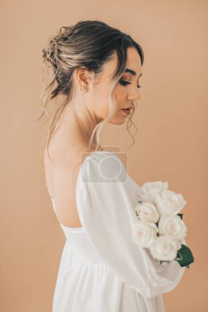 Foto de Primer plano de la mujer con elegancia sosteniendo rosas blancas - Imagen libre de derechos