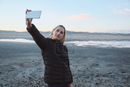 Téléchargez les photos : Une femme prend un selfie sur fond de montagnes et de lacs - en image libre de droit