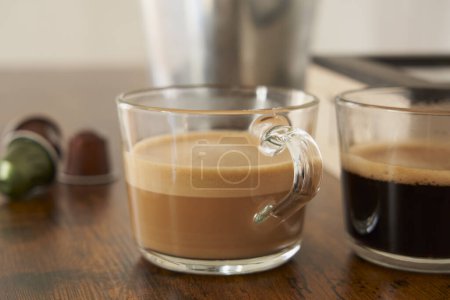 Téléchargez les photos : Cups of latte and black coffee with espresso capsules - en image libre de droit