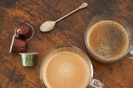Foto de Tazas de café con leche y café negro con cápsulas de espresso - Imagen libre de derechos