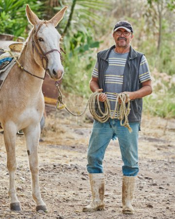 Téléchargez les photos : Agriculteur homme posant avec un cheval retournant sur caméra la vie rurale - en image libre de droit