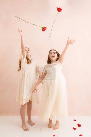 Photo for Two young girls throwing roses - Royalty Free Image