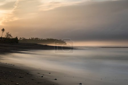 Téléchargez les photos : Plage de sable noir balien au lever du soleil à Bali Indonésie - en image libre de droit