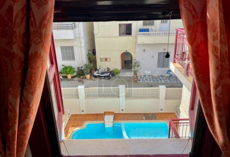 Téléchargez les photos : Vue de la piscine par la fenêtre de l'hôtel ridée - en image libre de droit