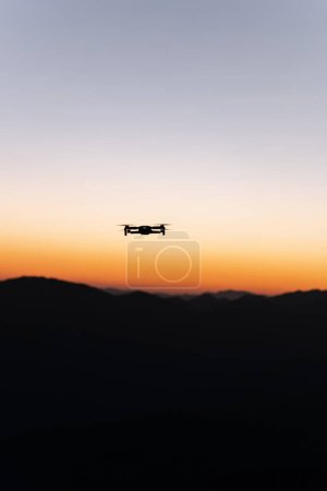 Téléchargez les photos : Drone flying with mountains in the background during sunrise - en image libre de droit