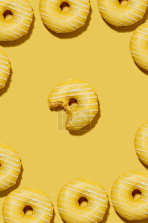 Téléchargez les photos : Lemon doughnuts in yellow glaze on a yellow background. pattern. - en image libre de droit