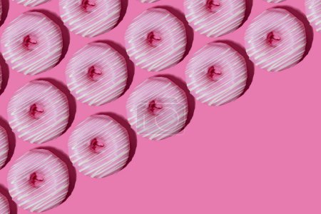 Foto de Rosquillas de frambuesa en esmalte rosa sobre un fondo rosa. patrón. - Imagen libre de derechos