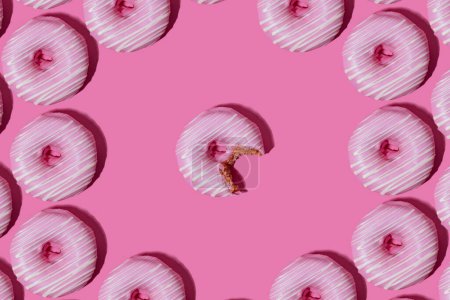 Foto de Rosquillas de frambuesa en esmalte rosa sobre un fondo rosa. patrón. - Imagen libre de derechos