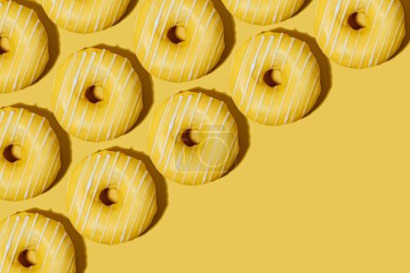 Foto de Rosquillas de limón en esmalte amarillo sobre un fondo amarillo. patrón. - Imagen libre de derechos