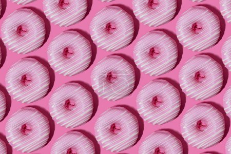 Foto de Raspberry donuts in pink glaze on a pink background. pattern. - Imagen libre de derechos